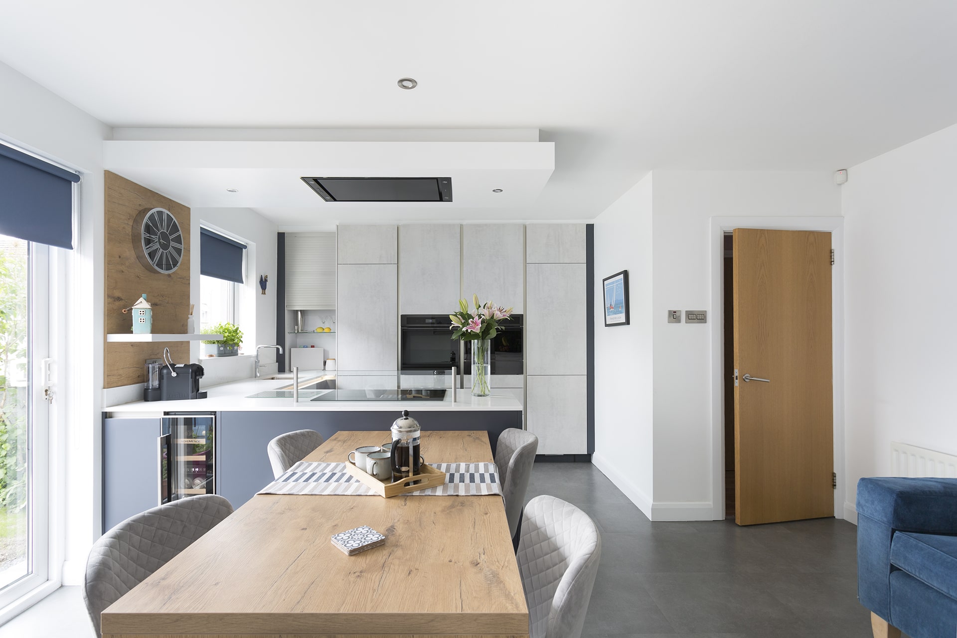 Modern kitchen with beautiful white and blue cabinets with wooden table