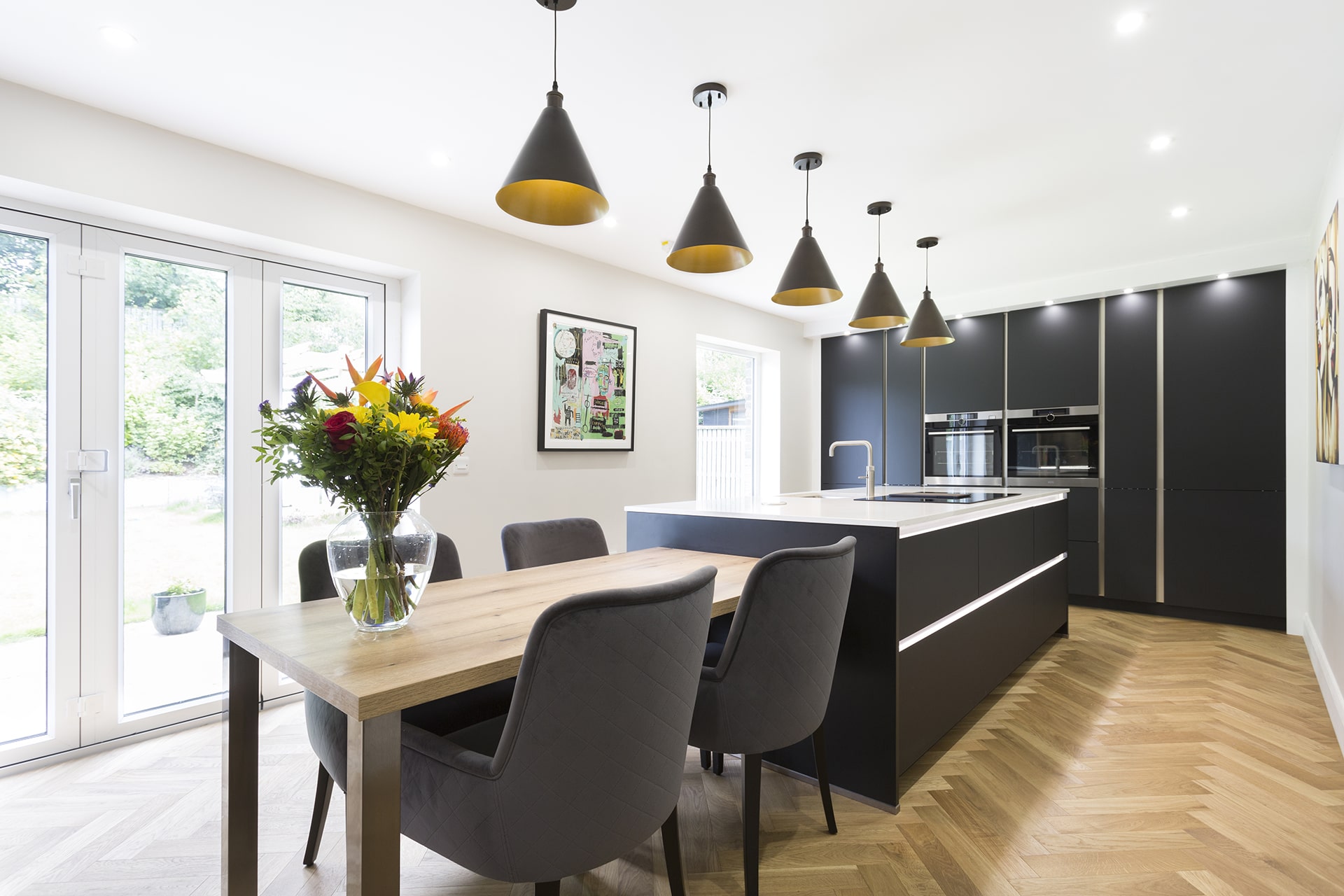 Modern kitchen with light counter, dark cabinets, and wooden floor