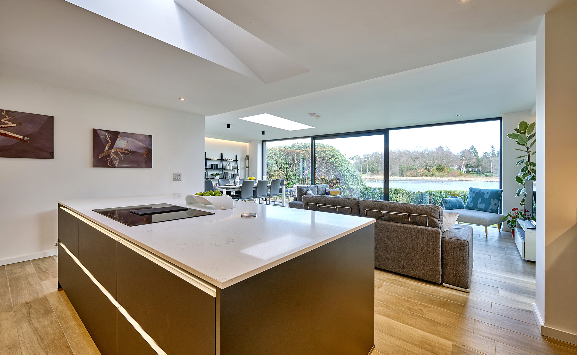 Modern kitchen with open plan design, dining table, living area and kitchen island with hob