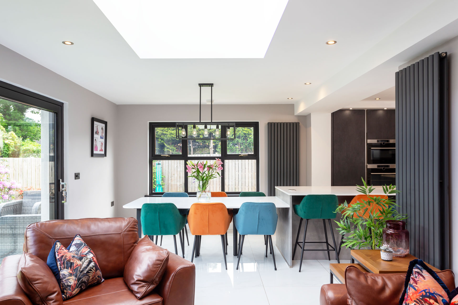 Modern kitchen with living area beside the dining table with plenty of natural light coming in