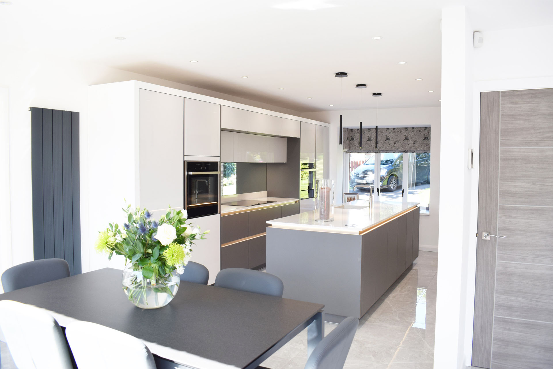Modern kitchen with open plan dining table at the end of the kitchen island